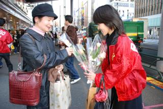 RENGO member hands out roses (near Marion in Yurakucho district of Tokyo)